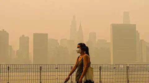 Selcuk Acar/Anadolu via Getty Images Smoke from massive wildfires in Canada engulfed the New York City skyline, reducing visibility and casting an orange haze over the New York City