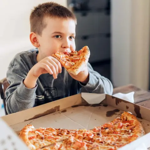 Getty Images Child eating a pizza