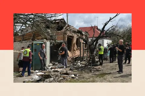 AFP via Getty Images A Ukrainian house that has been destroyed by a Russian airstrike. People are standing around the wrecked building