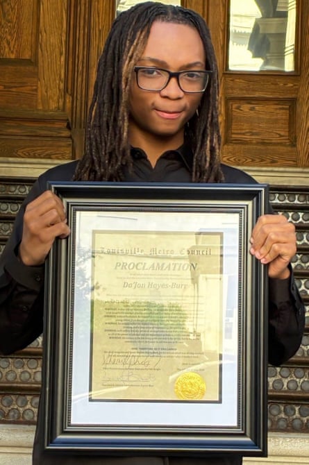 a young boy holding a picture frame