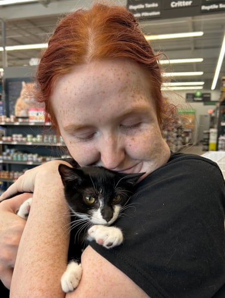 a woman holding a black and white cat