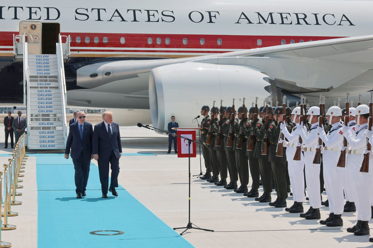 US President Donald Trump walks with Turkish President Tayyip Erdogan as he arrives aboard Air Force One at Etimesgut Air Base for a NATO summit.