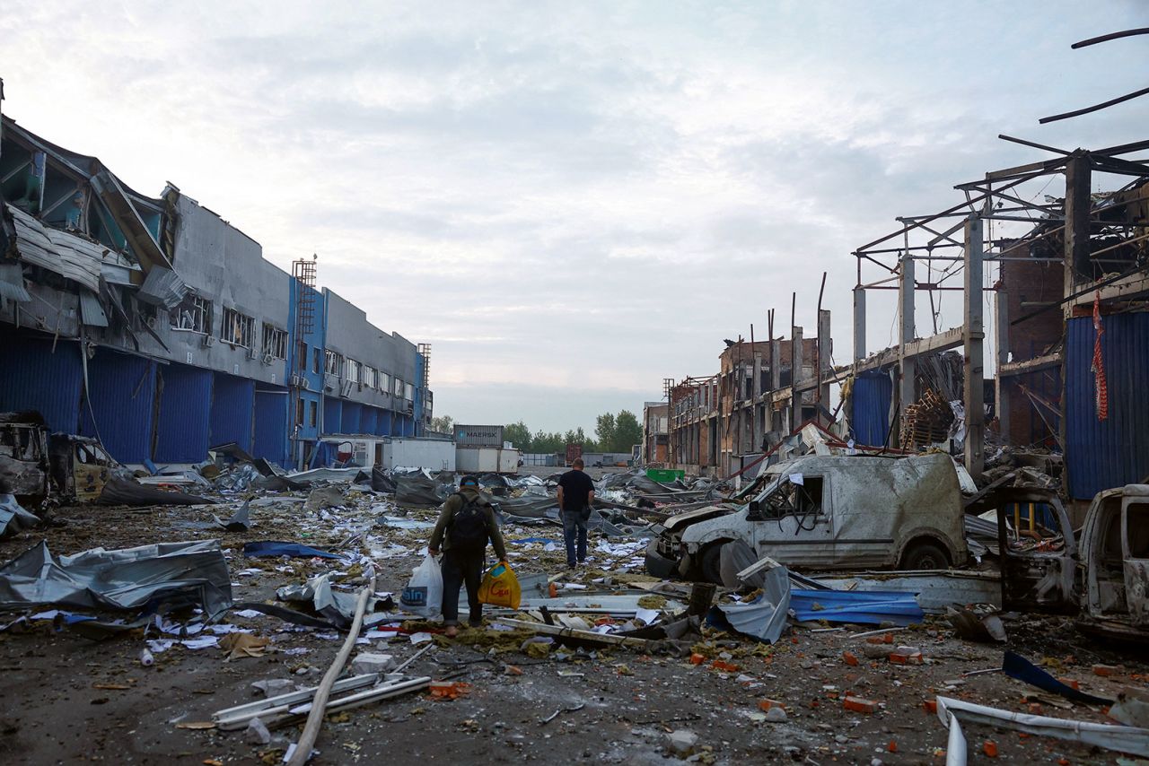 Employees walk among debris at the site of food and drink warehouses hit by an overnight Russian missile strike in Kyiv, Ukraine, on Wednesday.
