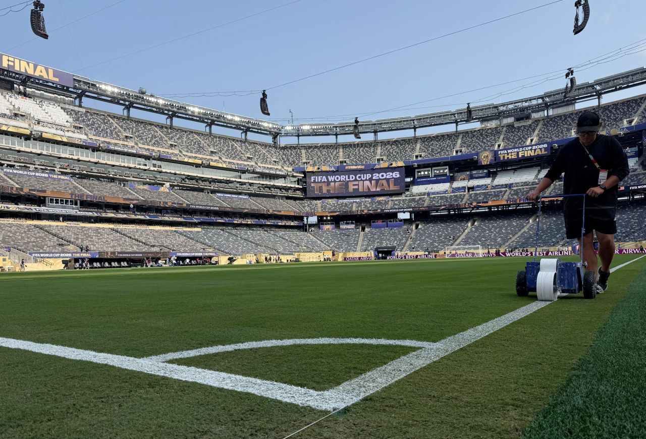 A member of the grounds staff paints pitch lines inside MetLife Stadium on Sunday.