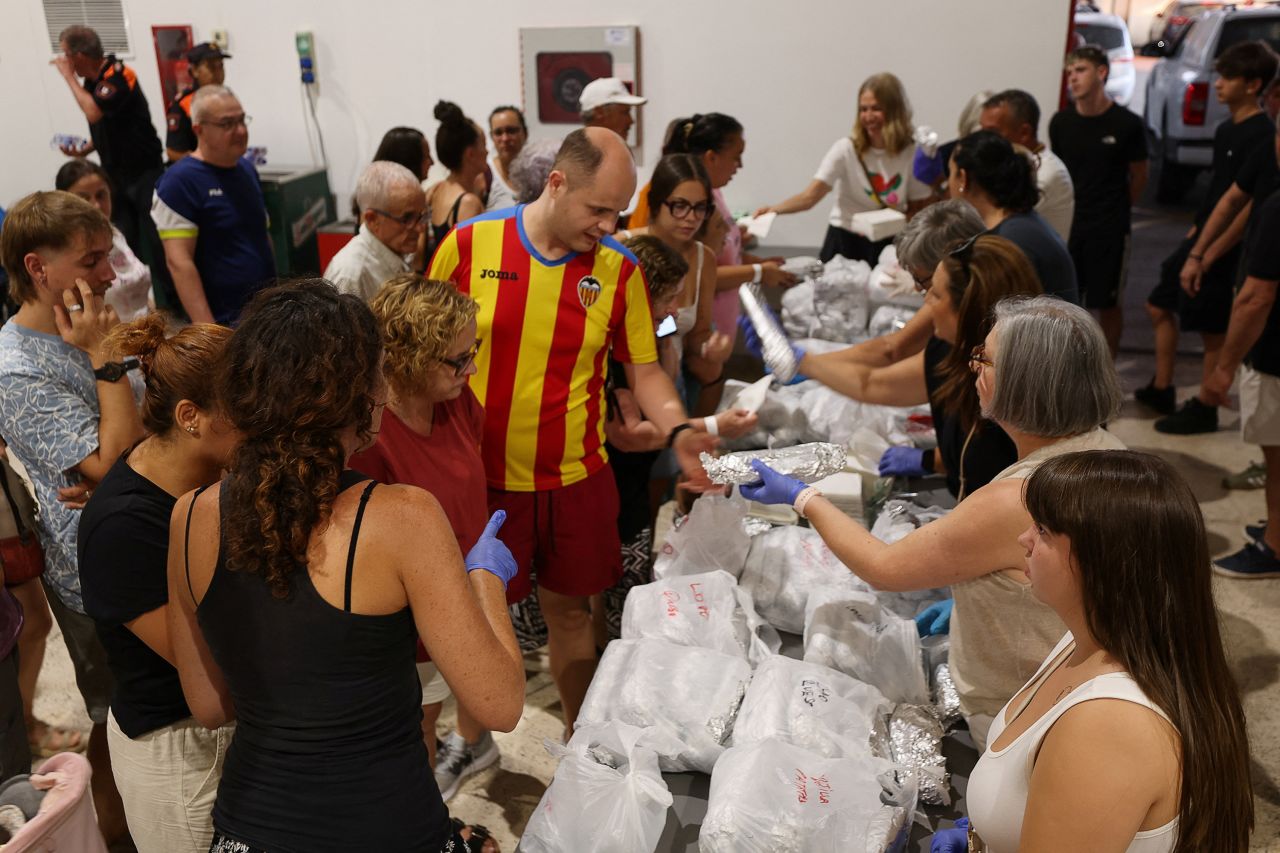 People from evacuated villages, receive food as they shelter at a sports center in Moncofa, Castellon, Spain, July 26.