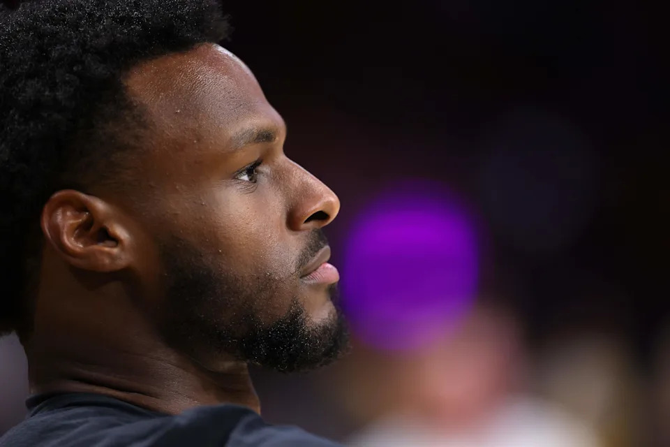 Bronny James looks on during a Lakers game. Los Angeles reportedly remains encouraged by his development despite its looming roster decision.