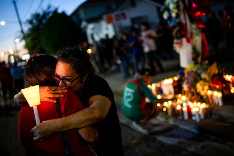 People embrace as they pay their respects to Lorenzo Salgado Araujo during a candlelight vigil on July 08, 2026 in Houston, Texas.