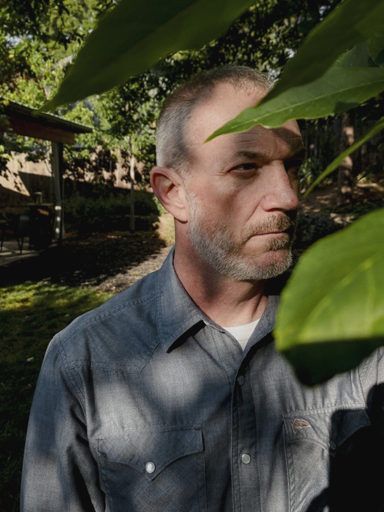 Joe Pollard stands near a green-leafed tree at a home in Boise.