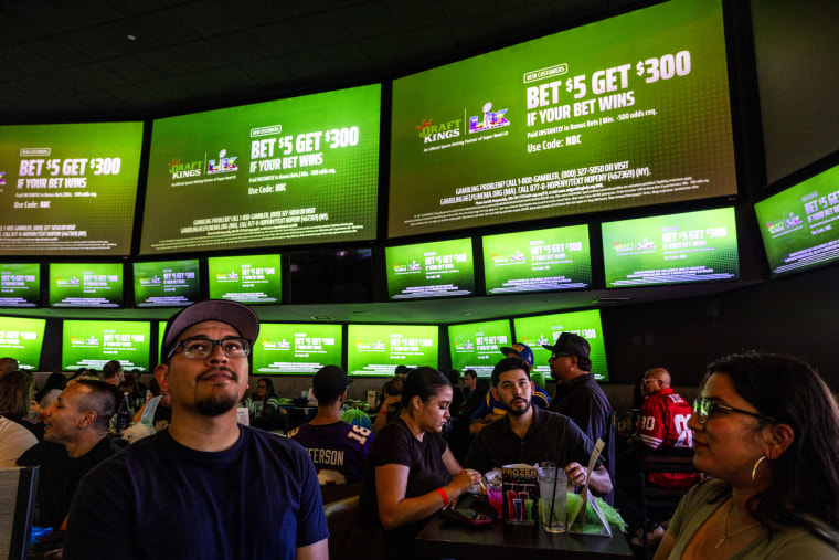 A commercial for Draft Kings during the Super Bowl LX broadcast on television screens at a bar