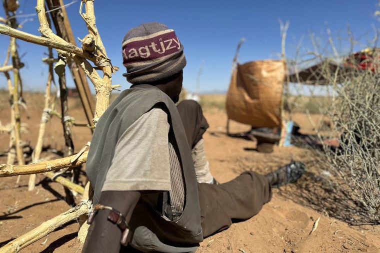 Sudanese displaced man sits at a makeshift shelter in Sudan.