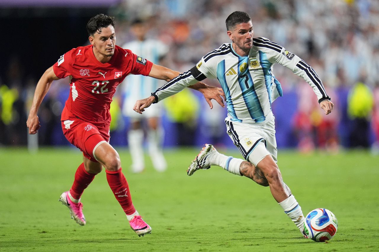 Argentina's Rodrigo de Paul, right, controls the ball as he is chased by Switzerland's Fabian Rieder.
