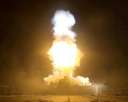 A night shot of a burst of flame above a naval vessel