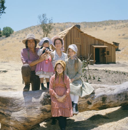 Frontier family smiling while standing outside cabin