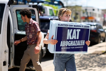 a woman carries a stack of signs with her name on them