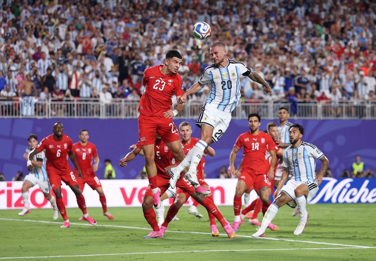 Argentina's Alexis Mac Allister attempts a header against Switzerland's Zeki Amdouni.