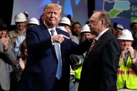 a man points at another man while placing a hand on his shoulder