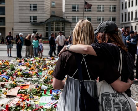 People look at tributes left in front of the Brandenburg Gate.