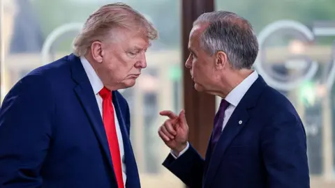 Getty Images US President Donald Trump speaks with Canada's Prime Minister Mark Carney during a work lunch as part of the G7 summit, in Evian, eastern France, on 16 June 2026.