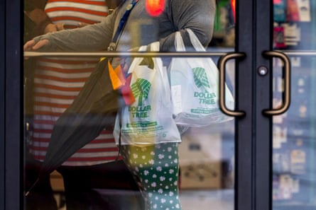 People carry Dollar Tree plastic bags as they head towards the door