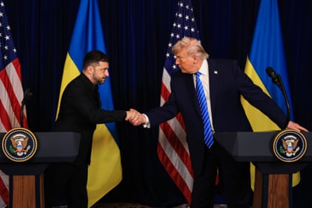 Two men in suits shake hands