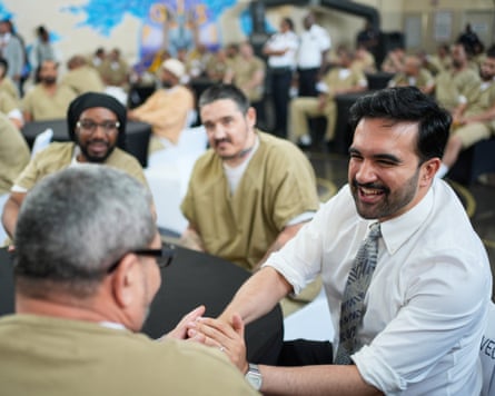 Mamdani shakes hands with a prisoner.
