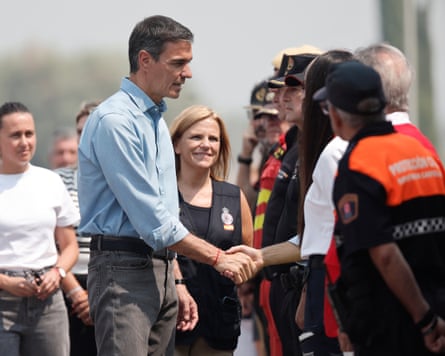 Pedro Sánchez shaking hand with members of the emergency services