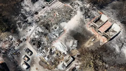 Reuters Drone view showing burnt-out houses and cars in Le Porge