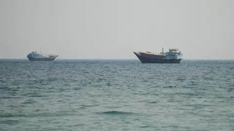 Reuters Two vessels in the Strait of Hormuz, as seen from Musandam, Oman.
