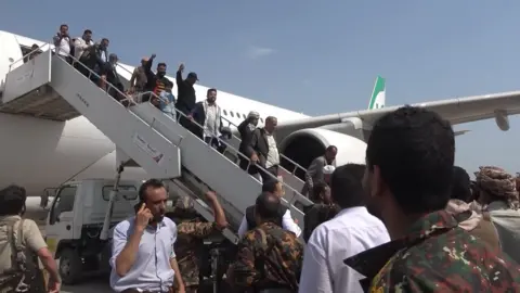 EPA Screengrab from an Al Masirah TV handout video showing members of a Houthi delegation getting off an Iranian Mahan Air passenger plane at Hudaydah's airport, in western Yemen (13 July 2026)