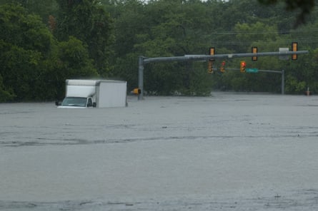 A white-paneled truck sitting in water almost up to the windshield.
