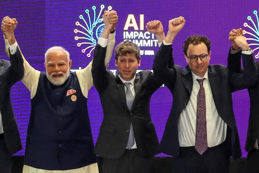 TOPSHOT - India's Prime Minister Narendra Modi (L) takes a group photo with AI company leaders including OpenAI CEO Sam Altman (C) and Anthropic CEO Dario Amodei (R) at the AI Impact Summit in New Delhi on February 19, 2026. (Photo by Ludovic MARIN / AFP via Getty Images)