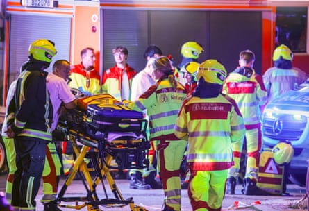 Emergency personnel work near the scene at night