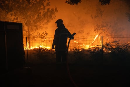 A firefighter battles a wildfire spreading in Lège-Cap-Ferret in the Gironde