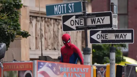 PA Media Spiderman looking at the camera with "one way" road signs behind him