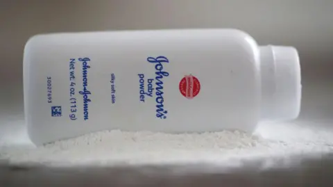 Getty Images A bottle of Johnson and Johnson Baby Powder is seen in a photo illustration placed on its side on top of some white baby powder