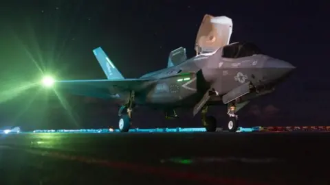 US Central Command A US F-35 fighter on an aircraft carrier with a night sky