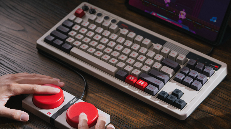 A person pressing the large A and B buttons connected to the 8BitDo Retro Mechanical Keyboard
