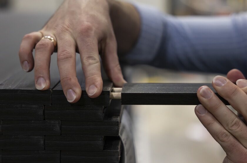 A worker demonstrates how furniture pieces are assembled, during a tour at Inno Line, a 538,000-square-foot production facility in Klaipėda, Lithuania, on April 22.