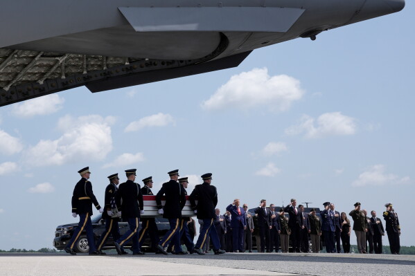 President Donald Trump and Secretary of Defense Pete Hegseth and others, salute as a U.S. Army carry team moves a transfer case containing the remains of Sgt. Angel S. Rampersad, of Ozone Park, N.Y. Wednesday, July 22, 2026, at Dover Air Force Base, Del. (AP Photo/Matt Rourke)