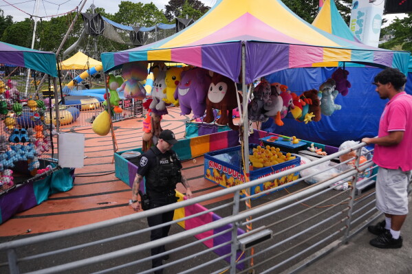 A police officer responds after a shooting at Seattle Center during the Bite of Seattle food festival Sunday, July 26, 2026, in Seattle, Wash. (AP Photo/Lindsey Wasson)