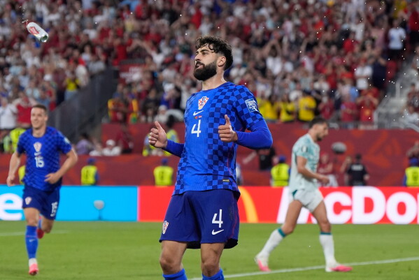 A beer can flies through to air near Croatia's Josko Gvardiol (4) during the World Cup round of 32 soccer match between Portugal and Croatia in Toronto, Thursday, July 2, 2026. (AP Photo/Mike Stewart)