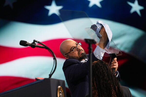 Gabriel Perez cleans the teleprompter before President Donald Trump speaks at the Future Investment Initiative Institute's summit, March 27, 2026, in Miami Beach, Fla. (AP Photo/Mark Schiefelbein, File)