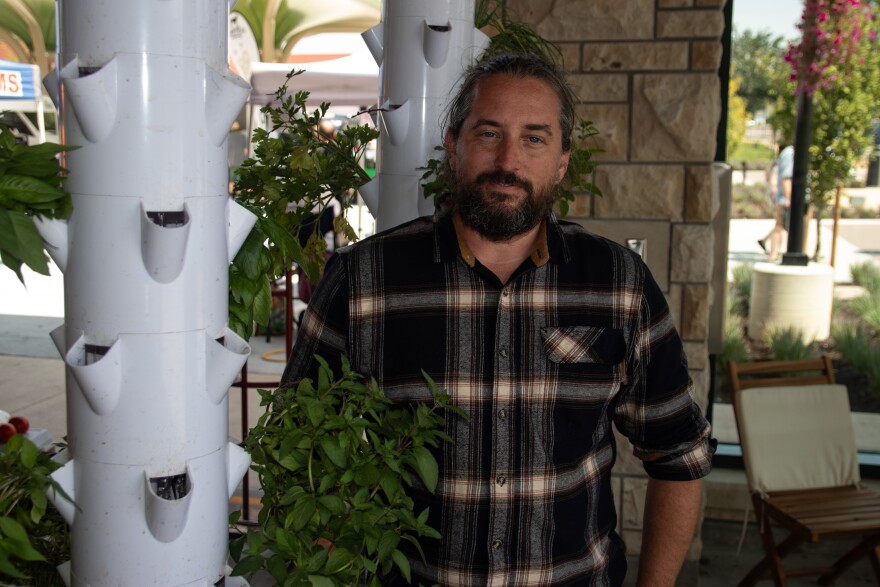 Chris Johnson stands next to his hydroponics stand. He sells herbs, lettuces and strawberries at the Overland Park Farmers' Market.