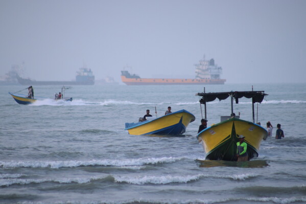 Small boats line the shore as cargo ships and other commercial vessels appear anchored in the Strait of Hormuz off Bandar Abbas, Iran, Monday, July 27, 2026. (Razieh Poudat/ISNA via AP)