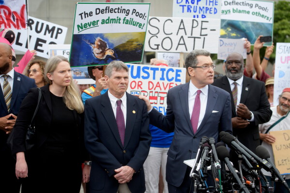 Former Olympic canoeist David Hearn, second from left, listens as his attorney Norman Eisen, right, speaks after he pleaded not guilty to allegedly damaging the Lincoln Memorial Reflecting Pool, Thursday, July 9, 2026, in Washington. (AP Photo/Rod Lamkey, Jr.)