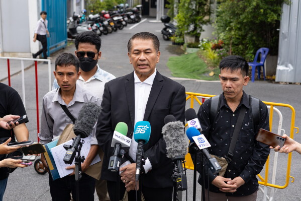 Lawyer Kunpat Singhathong and three sailors from the Thailand-flagged ship, the Mayuree Naree, speak to journalists outside the Central Labour Court in Bangkok, Thailand on Friday, July 10, 2026. (AP Photo/Anton L. Delgado)