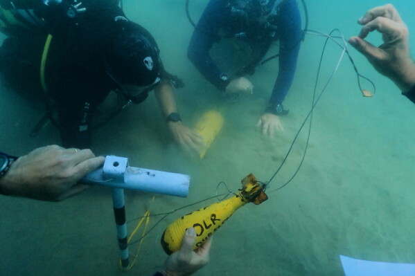 Divers place mock munitions on the floor of the Mediterranean Sea off the coast of Rishon LeZion, Israel, Sunday, June 21, 2026. (AP Photo/Sam Mednick)