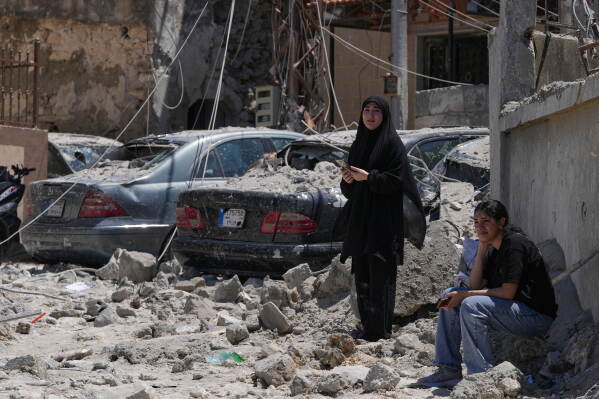 Relatives of missing victims weep, as they gather at the site of destroyed buildings that were hit in an Israeli airstrike in Qannarit village, southern Lebanon, Saturday, June 20, 2026. (AP Photo/Mohammed Zaatari)