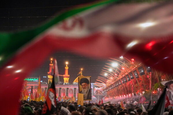 Mourners wait for the arrival of the funeral procession of the late Iranian Supreme Leader Ayatollah Ali Khamenei outside the Imam Hussein Shrine in Karbala, Iraq, Wednesday, July 8, 2026. (AP Photo/Khalil Hamra)