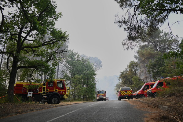 Fire trucks are parked near the scene of a wildfire in the region of the historic Fontainebleau forest, about 60 km (37 miles) south of Paris, France, Monday, July 13, 2026. (AP Photo/Emma Da Silva)